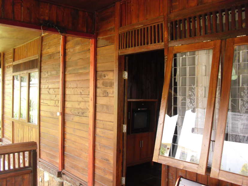 Veranda in front of a wooden house with open door and window